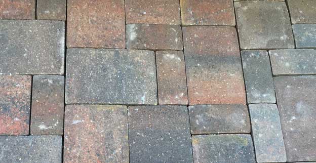 Concrete pavers installed in a pattern with different size bricks