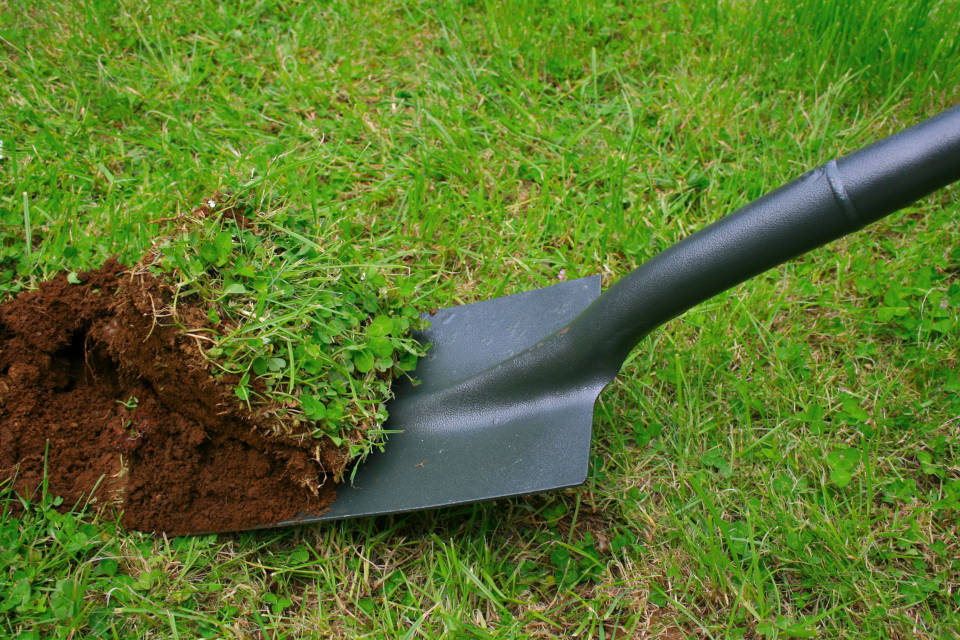 Excavate for a patio using a shovel and then tamp the surface