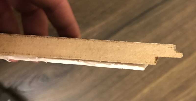 Use a table saw to trim small amount of the click joint off to use as a tapping block