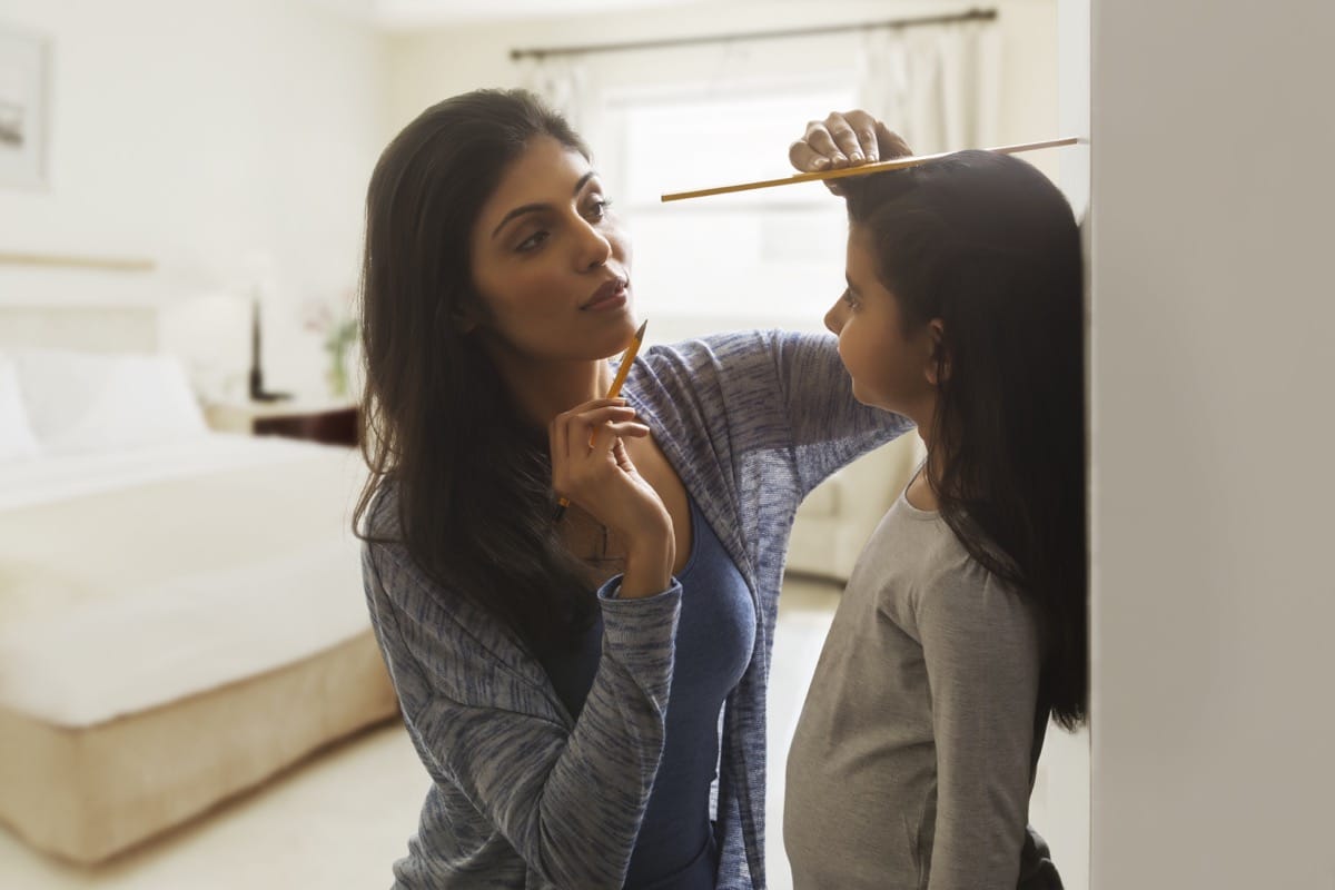 Mother measuring the height of a child