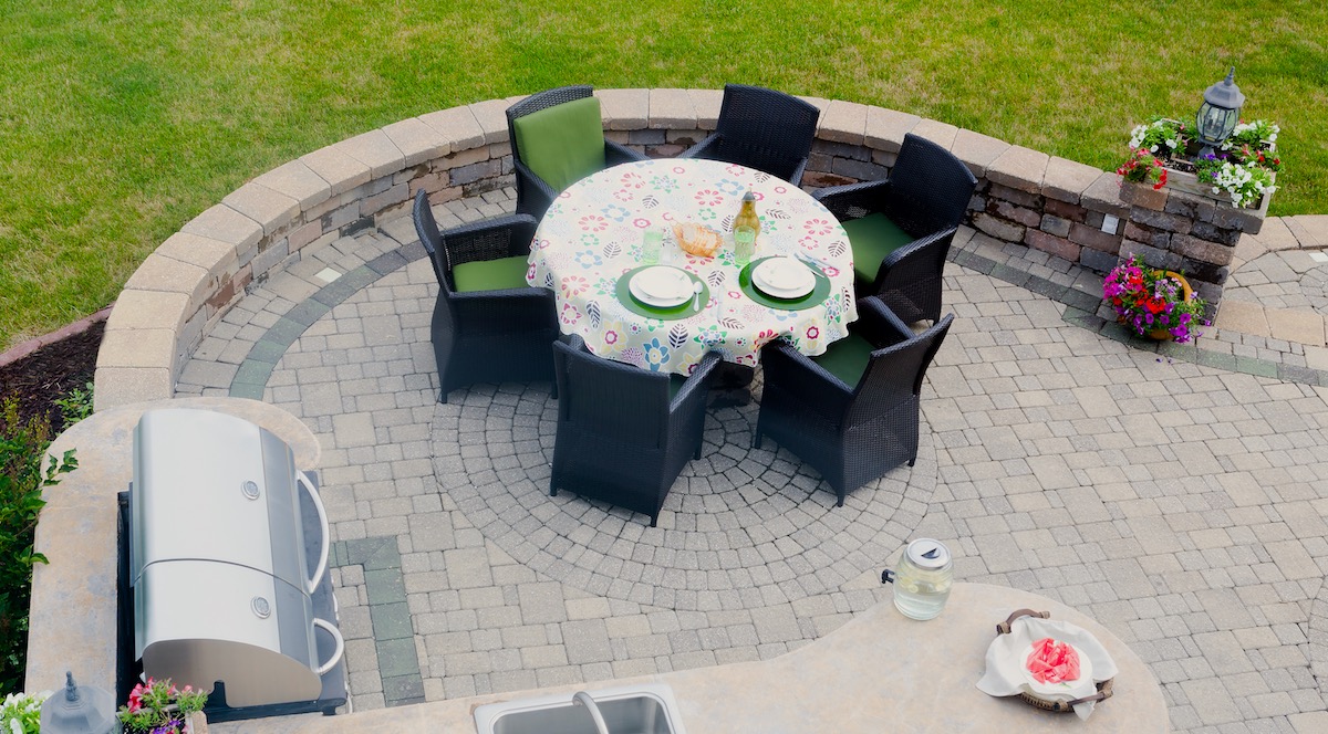 Newly installed paver patio with dining table and grill