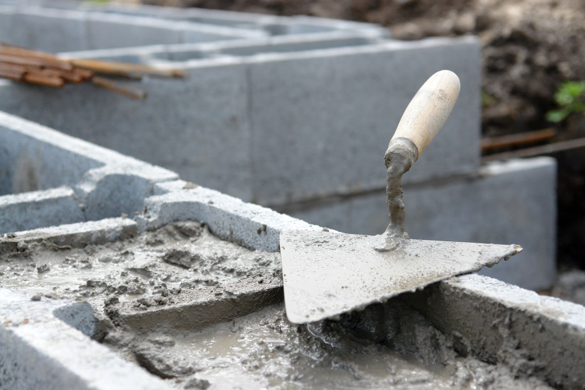 Concrete block wall reinforced by filling with concrete