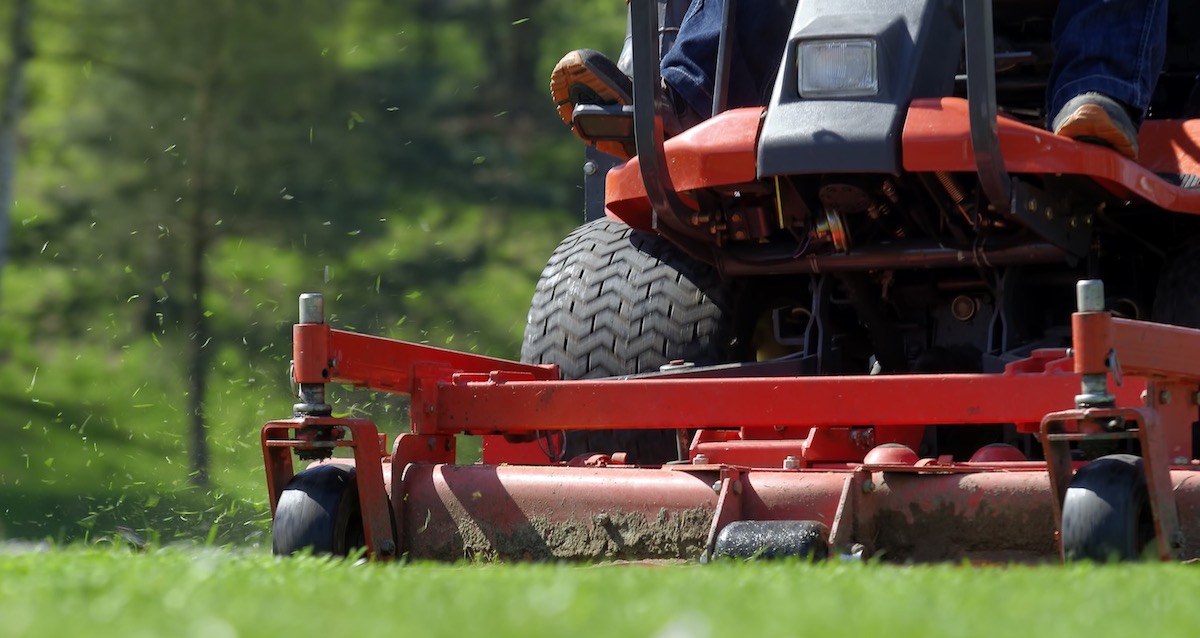 zero-turn riding lawn mower cutting the grass on a large lawn