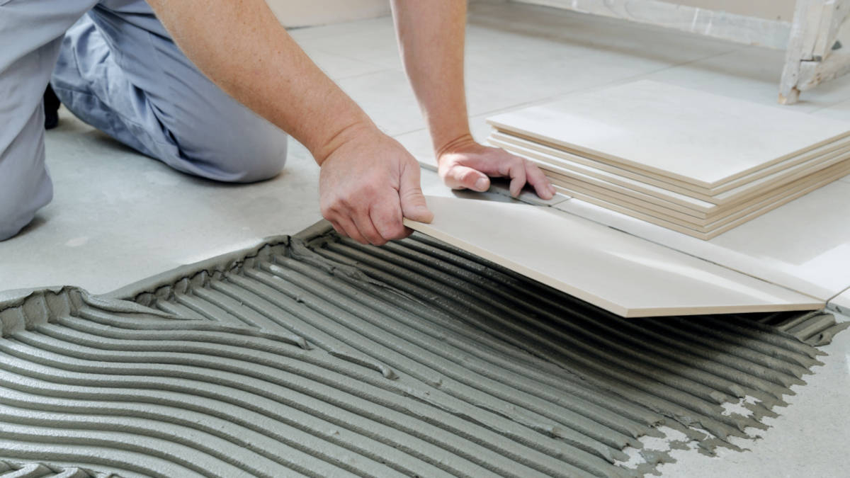 Flooring installer laying a tile floor