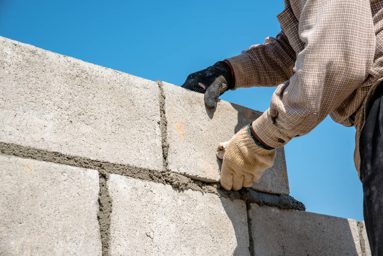 concrete block foundation wall being constructed by a mason