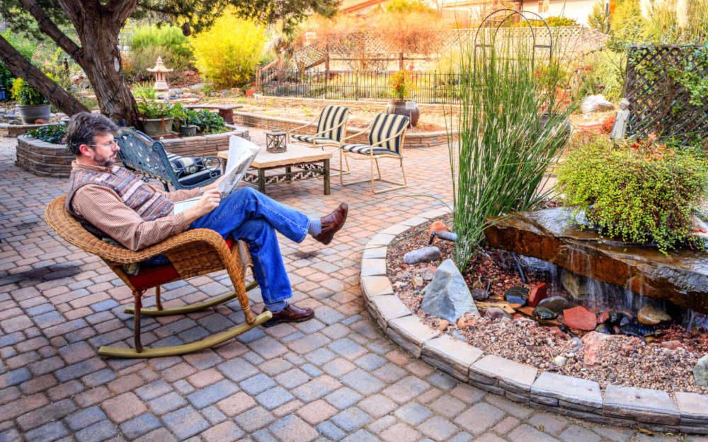 Newly estimated and installed paver patio with person sitting on a chair