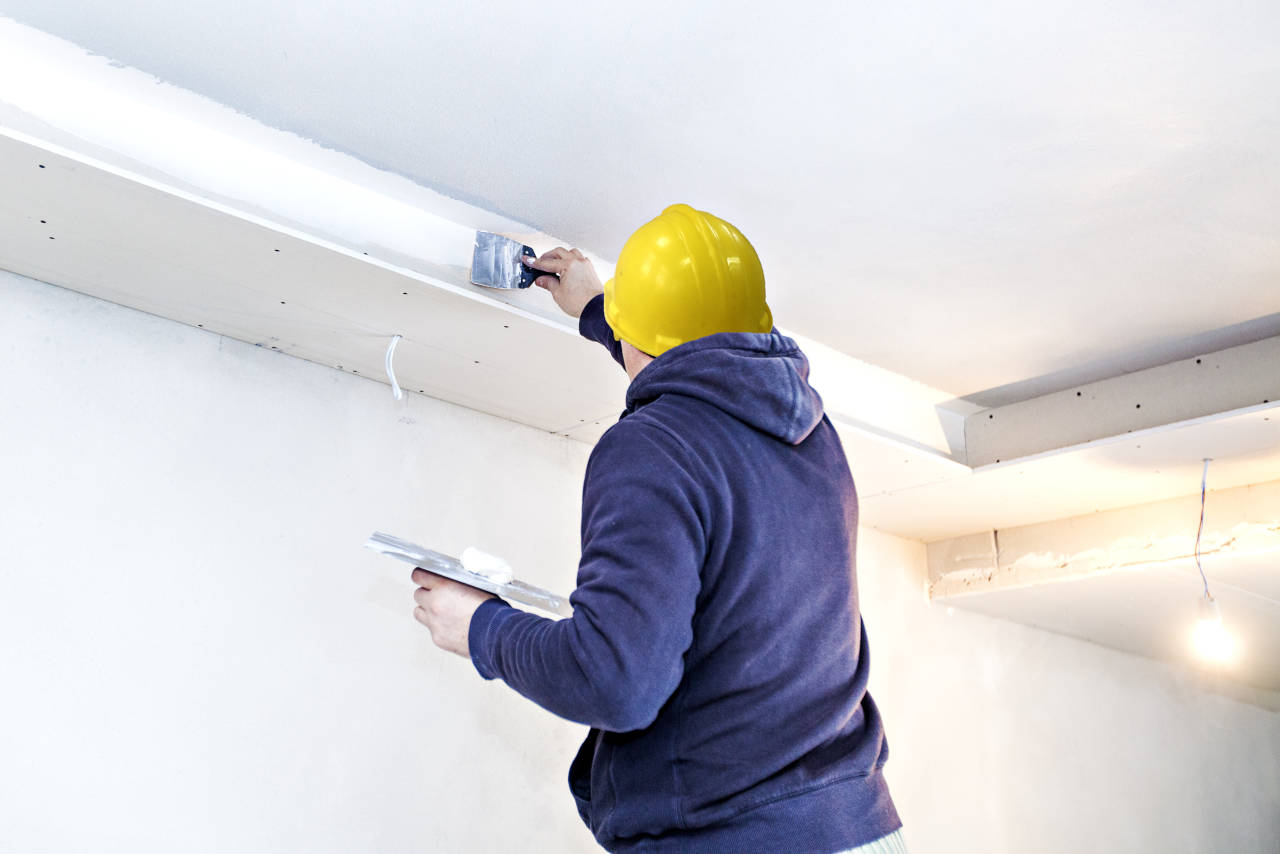 Drywall installer applying a code of mud