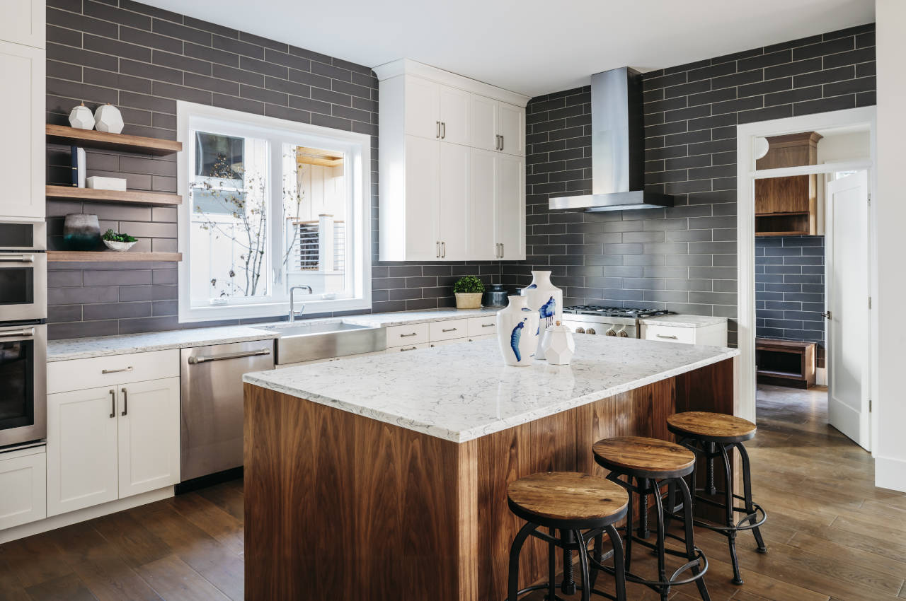 Kitchen with blue tile, a large island, and marble countertops
