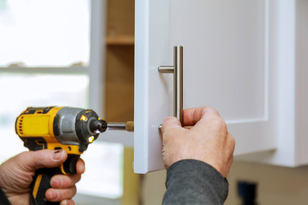 Person adding the finishing touches to a cabinet refacing project