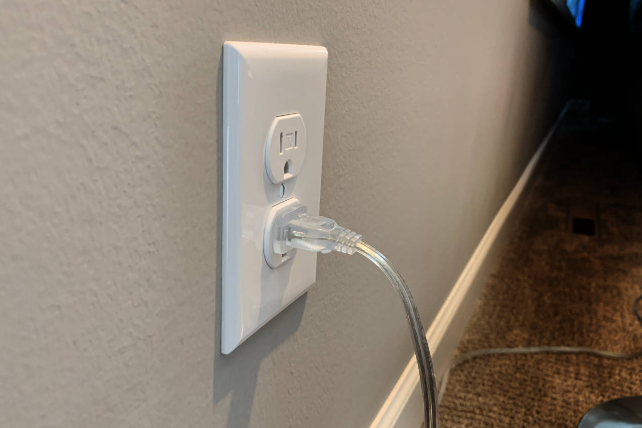 Electrical receptacle on a wall with a lamp cord plugged in