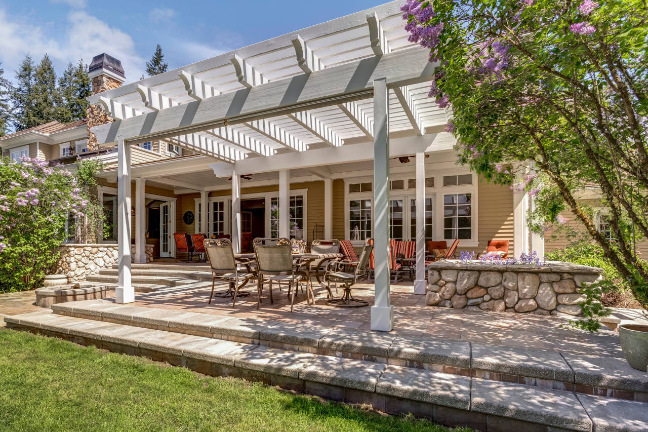 Pergola on a patio providing shade over a table.