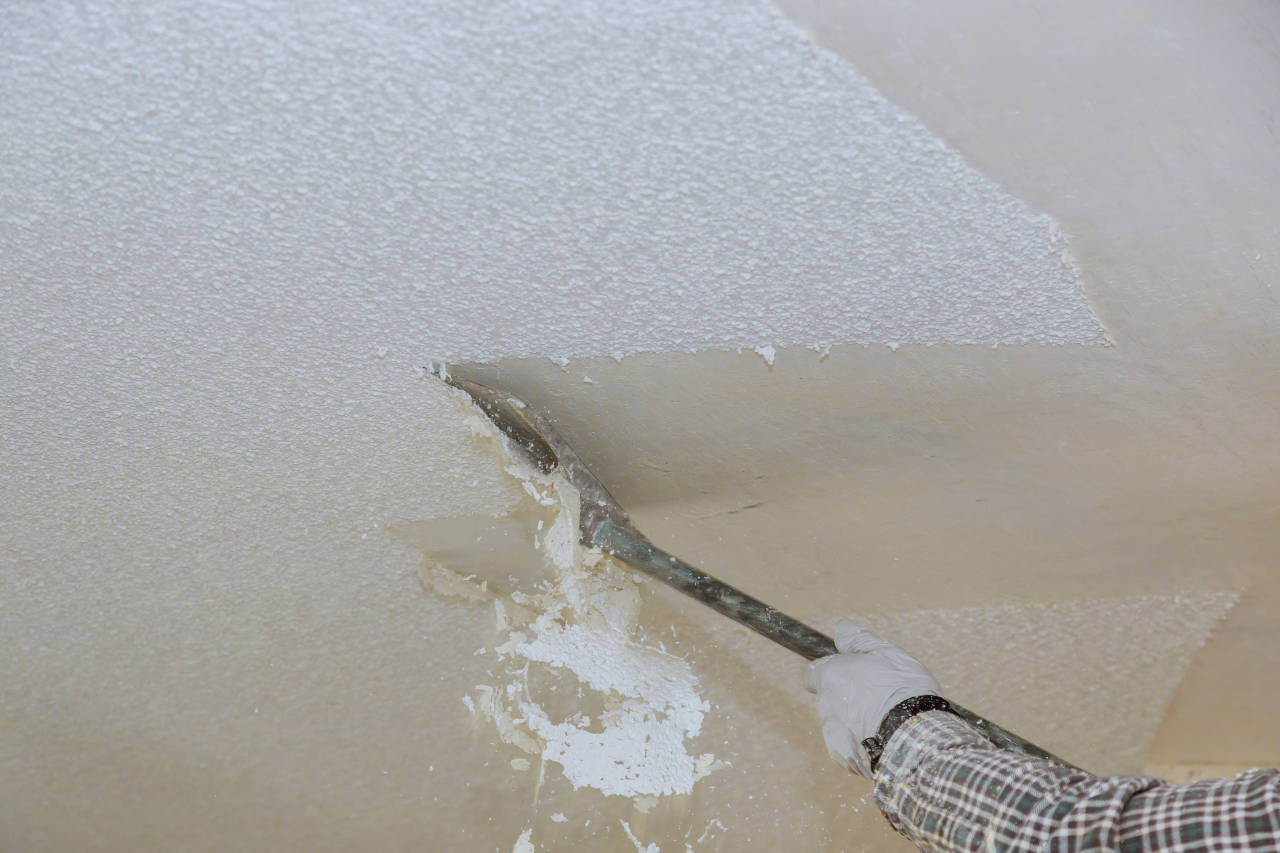 Contractor scraping a ceiling to remove the popcorn texture