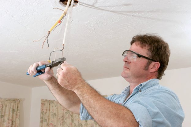 Electrician rewiring a light fixture