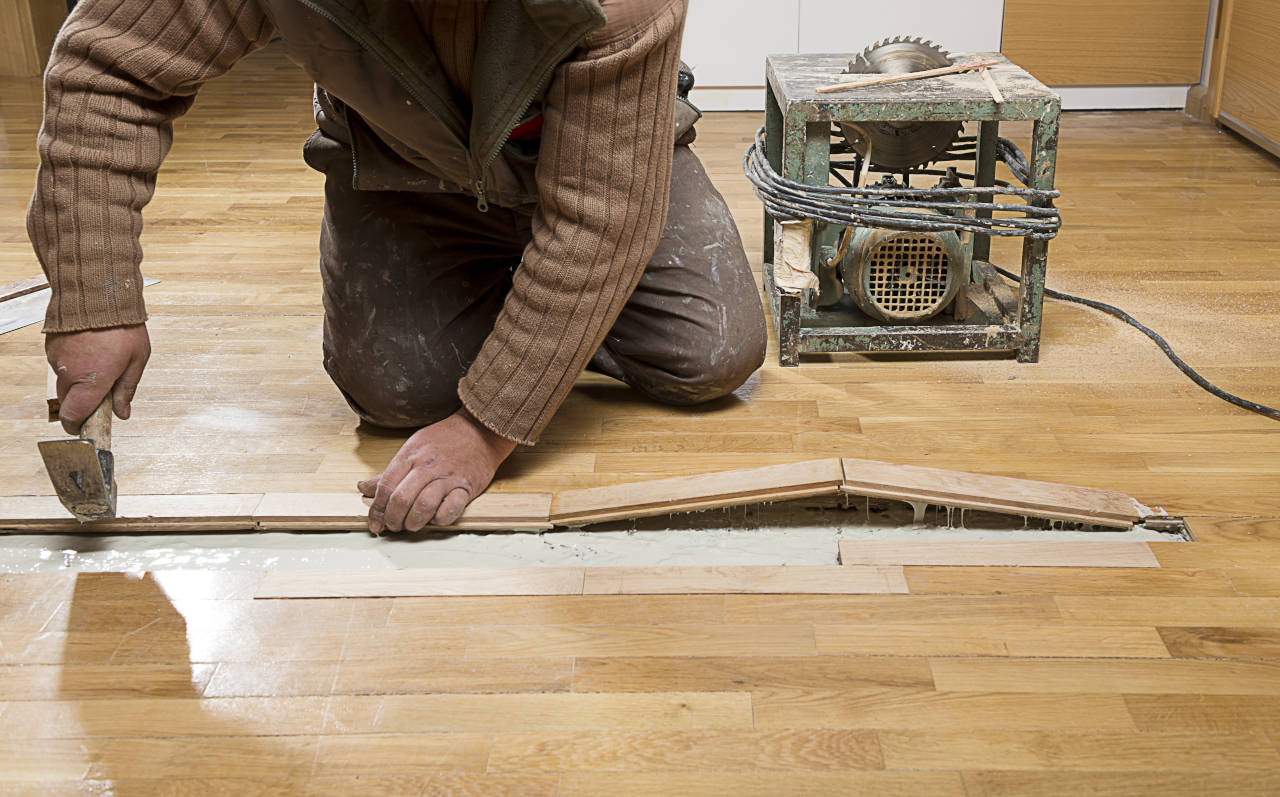 carpenter repairing a hardwood floor