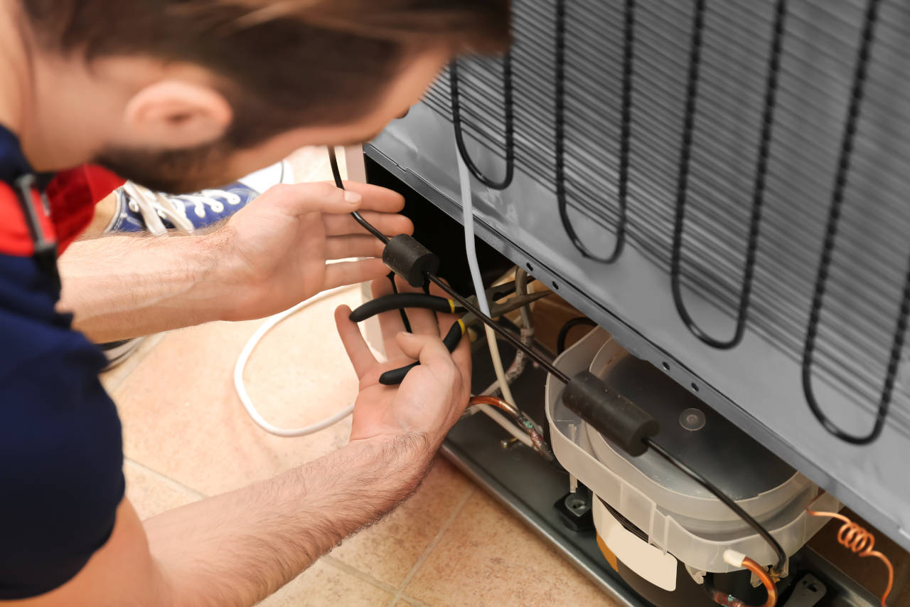 Technician repairing a refrigerator