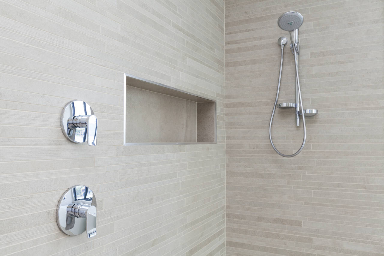 tile shower with cubby, shower head, and controls