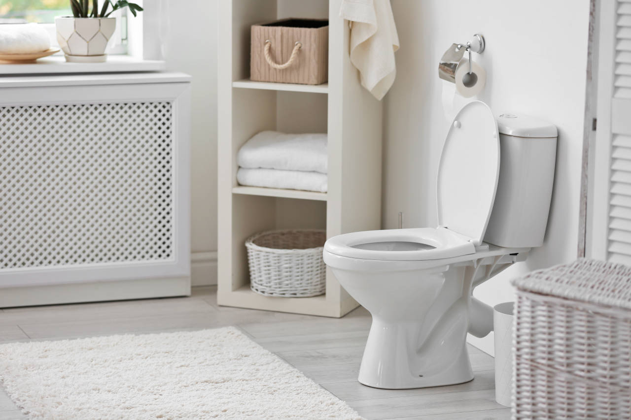 bathroom with light grey tile and porcelain toilet