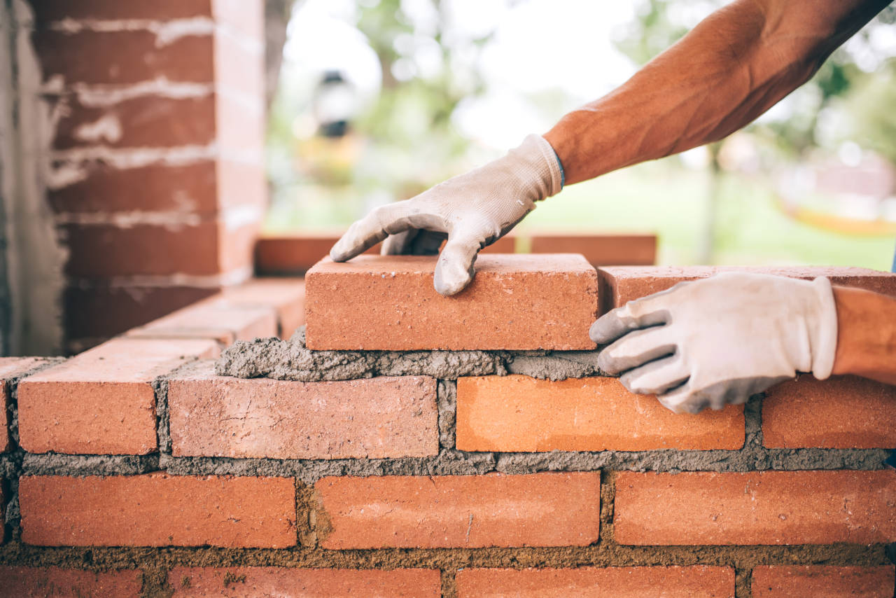 Mason installing a brick wall