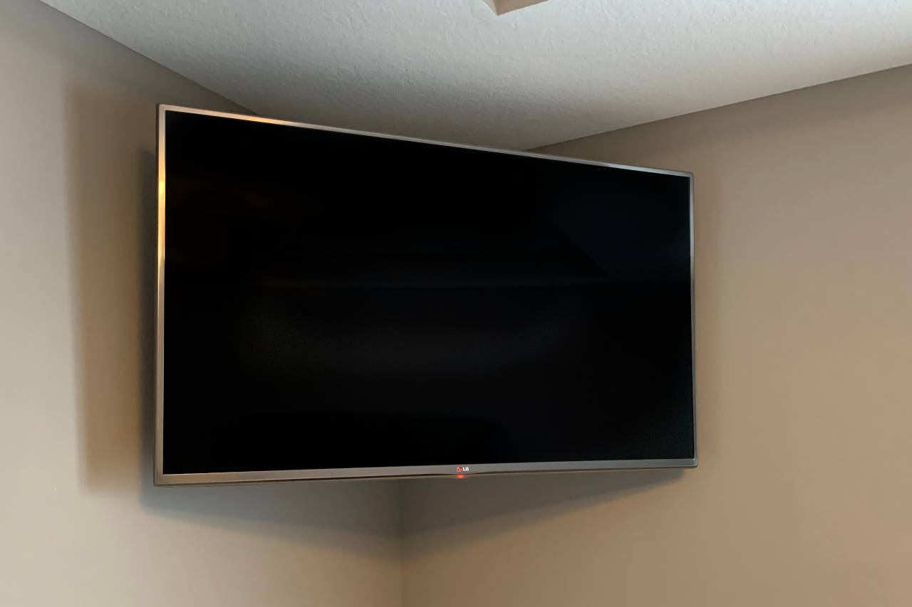 flat screen tv mounted in a corner using an articulated swivel bracket