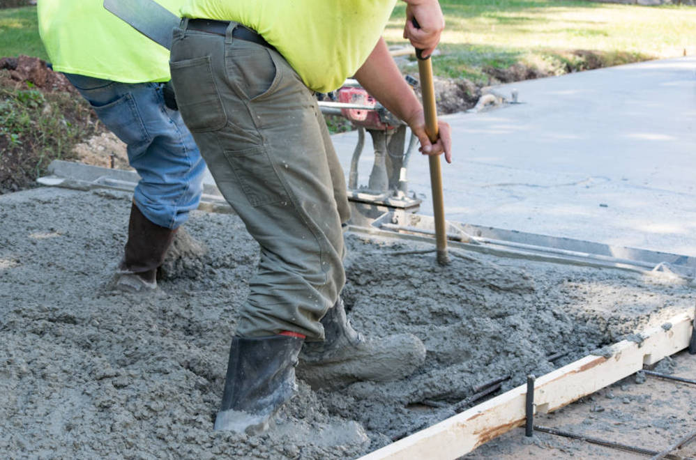 Contractors pouring and finishing a concrete slab