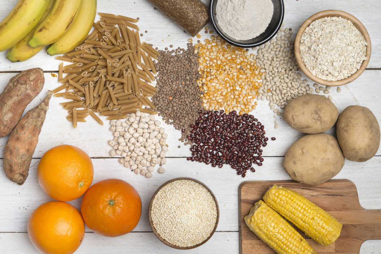 platter of food high in complex carbohydrates, including bread, pasta, starches, beans, and fruits