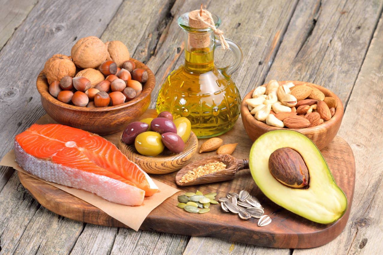 platter of foods high in healthy fats, including fish, walnuts, almonds, and avacado